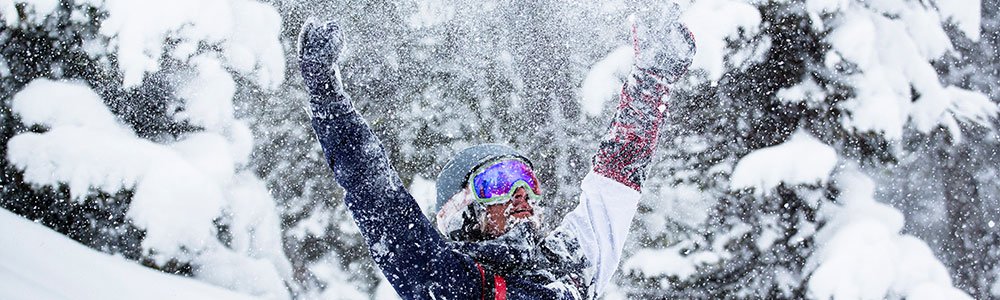 Snowboarders carving through fresh powder on Idaho's mountain trails, enjoying a snow-filled season of skiing and snowboarding at a premier resort with varied terrain, backcountry access, and lift tickets for every ski area and run.