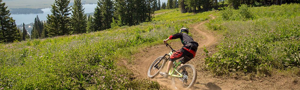 Biker going down hill on mountain trail